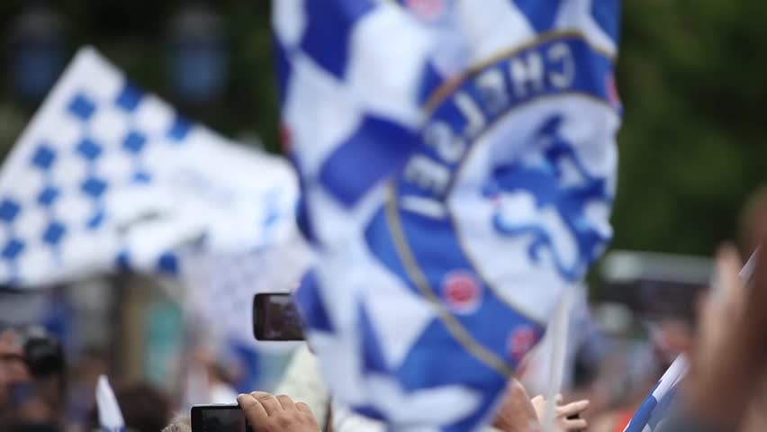 LONDON - MAY 20: Chelsea fans waving flags outside Stamford Bridge stadium to welcome back their team after historically winning the Champions League and The FA Cup in Chelsea, London, UK on May 20, 2012