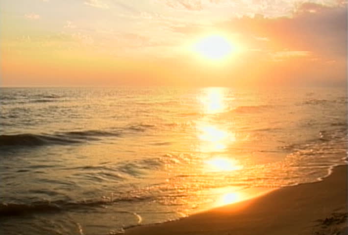 Golden sun sets over a sandy beach