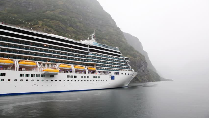 board of huge multideck liner standing at rocky coast