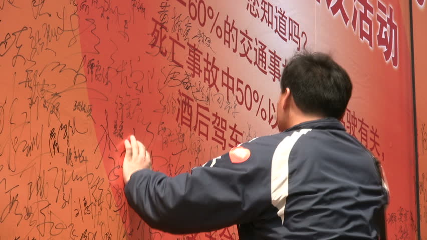 QINGDAO - MAY 11: People are writing their signature on a banner for an anti Drink & Drive campaign on May 11, 2010 in Qingdao, China