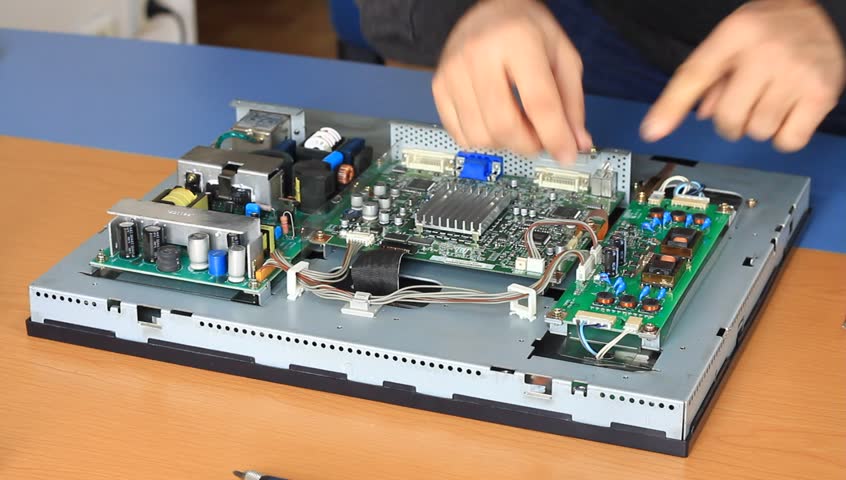 Electronic technician fixes circuit board cables at the repair service shop
