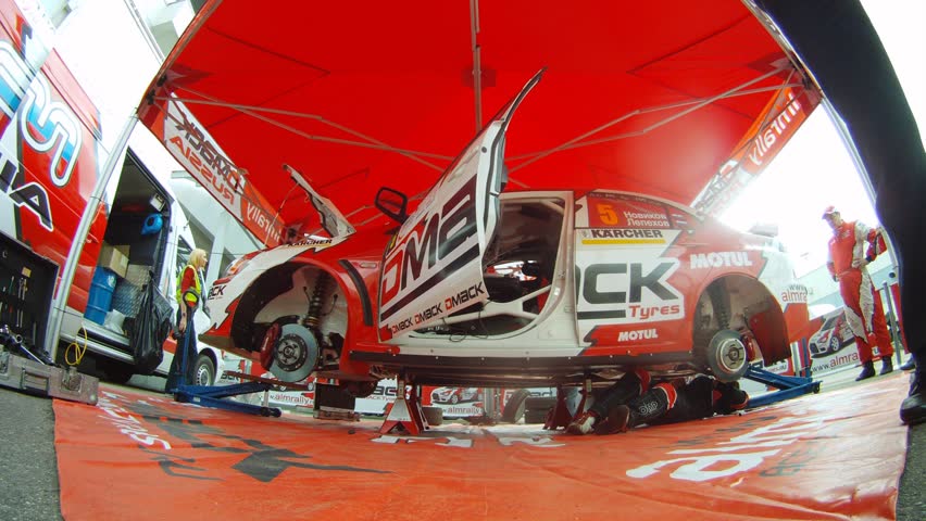 MOSCOW - APR 21: (Timelapse View) Automobile mechanic establishes wheels on car of team ALM RUSSIA before start, on Rally Masters Show, on April 29, 2012 in Moscow, Russia