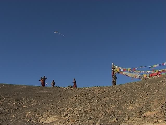 Young Buddhist monks flying a kite in the Himalayas