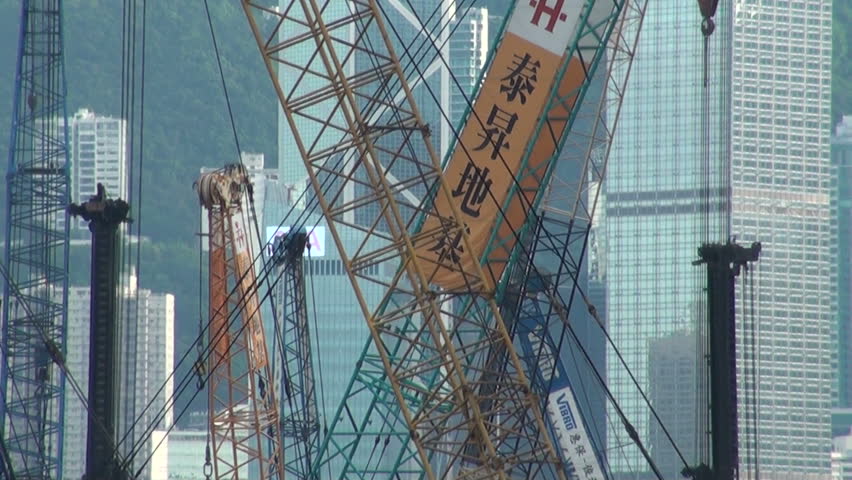 HONG KONG - 27 JULY 2010: Cranes are moving in front of skyscrapers in Hong Kong, China