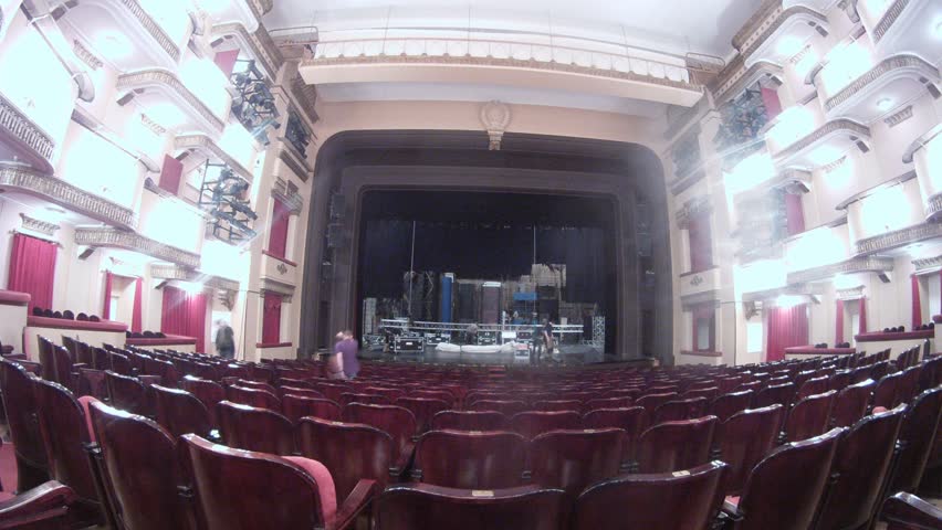 Working scenes dismantle scenery after performance before empty spectator hall in theatre, time lapse