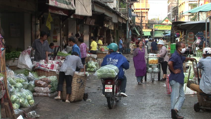Bangkok, Thailand - CIRCA December, 2006: A very busy and crowded market street with motorcycles and vendors