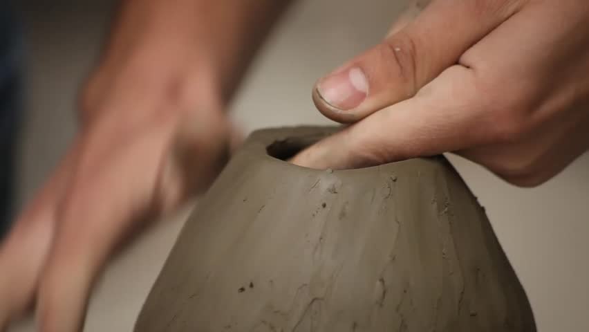 Pottery class workshop. Clay shaping on potter's wheel.
