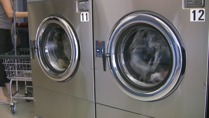 Clothes in a pair of good-looking chrome laundry machine go through their cycles.