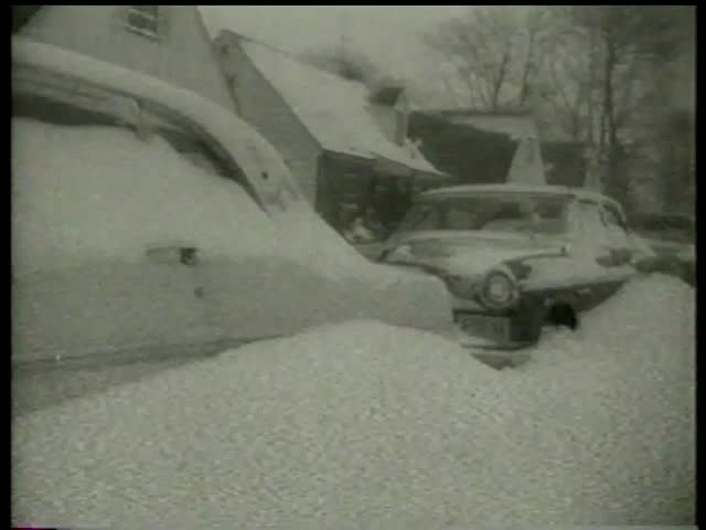 Cars are buried in snow on streets in towns during and after a snowfall in the USA circa 1958 - MGM PICTURES, UNIVERSAL-INTERNATIONAL NEWSREEL, USA, filmed in 1958