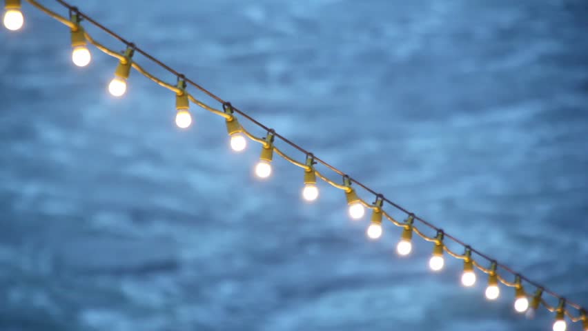 Garland with illumination on deck of ship which floats in sea