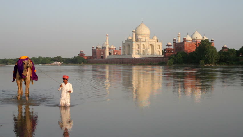 UTTER PRADESH, INDIA - CIRCA MAY 2011: Taj Mahal, UNESCO World Heritage Site, across the Jumna Yamuna River, Man leading camel