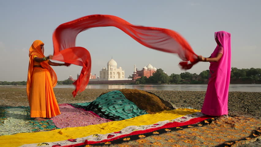 UTTER PRADESH, INDIA - CIRCA MAY 2011: Taj Mahal, across the Jumna Yamuna River, Women drying colourful Saris