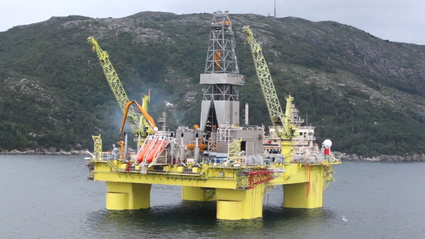 Seagulls fly over drilling platform in gulf of Stavanger
