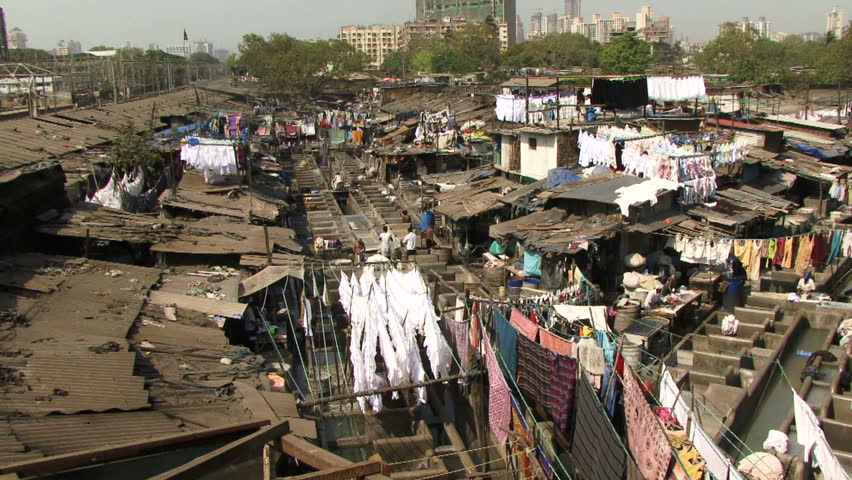 Mumbai, India - May 15, 2011: People washing laundry in a slum in India. Over 400 Million are classed as ultra poor in India. Poverty rates are higher than some East Asia countries such as Vietnam.