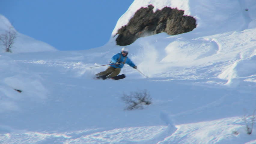 Male skier carving through steep terrain