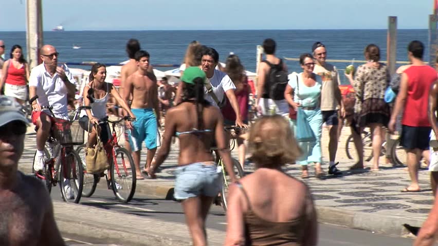 RIO DE JANEIRO, BRAZIL - CIRCA 2010:Crowded Beach In Rio De Janeiro, Brazil, Focus On Bicycle Rider