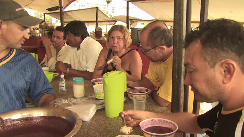 AMAZON REGION, BRAZIL - CIRCA 2010:  People eating local indigenous food made from acai berries