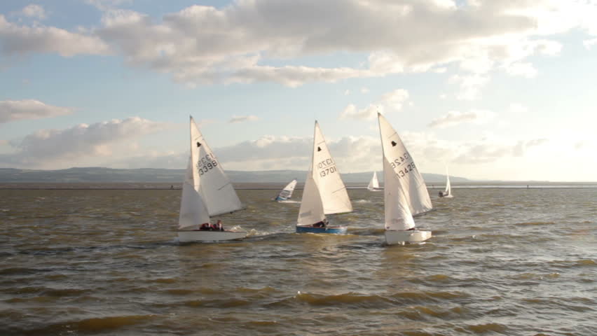 WIRRAL, CHESHIRE/ENGLAND - JUNE 12: Sailing dinghies on West Kirby Marine Lake race past a buoy on June 28, 2012 in Wirral. The Marine Lake is a man made coastal lake fed by the sea at high tide.
