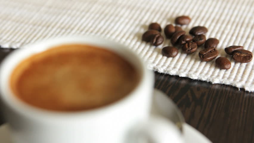 Cup with coffee near coffee grains