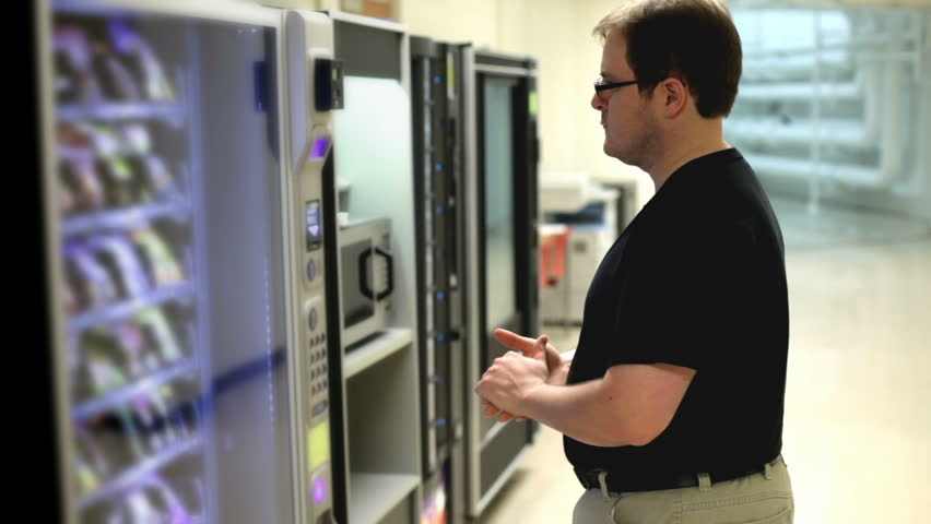 Man pondering decision at vending machine