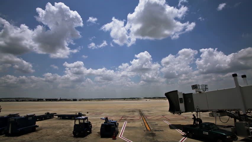 HOUSTON - CIRCA JULY 2012: Time lapse of airplane taxing into gate unloading and loading before the next flight, as clouds develop and pass over head circa July 2012 in Houston, Texas.