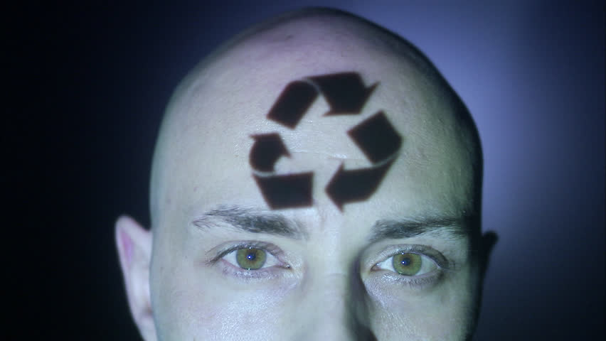 A man with recycling symbol projected on his face.
