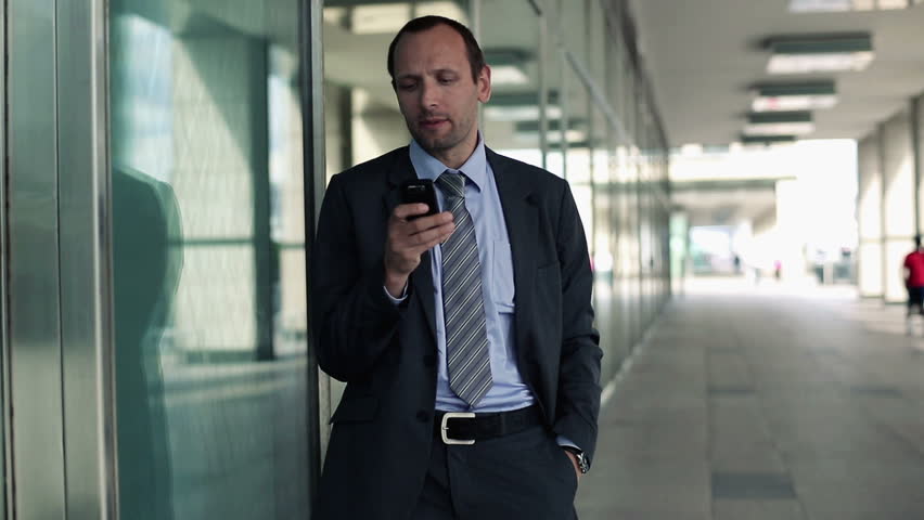Young handsome businessman with smartphone in the city
