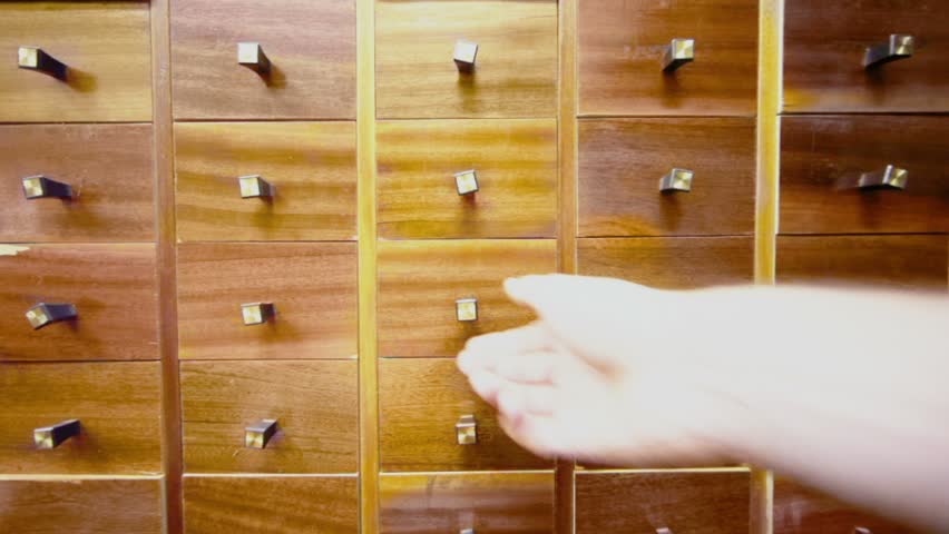Hand opens compartment in cabinet and takes cd disk from it, then close