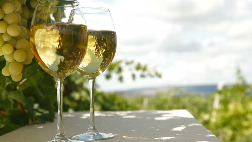 Two glasses of white wine and bunch of muscat white grapes, tracking shot
