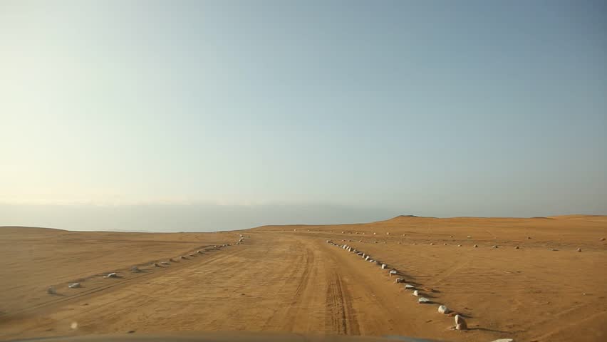 video footage of a onboard-camera in a car driving through the desert of the Paracas National Parc in Peru, south america