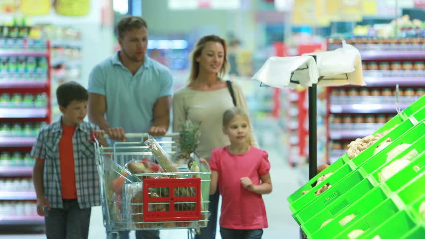 Family stopping by a vegetable section to take fresh cabbage