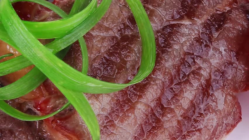 roasted beef meat strips on white ceramic plate isolated over white background