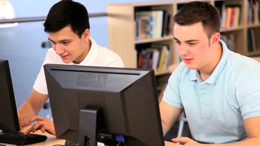 Caucasian and Indian male classmates e-learning in modern classroom
