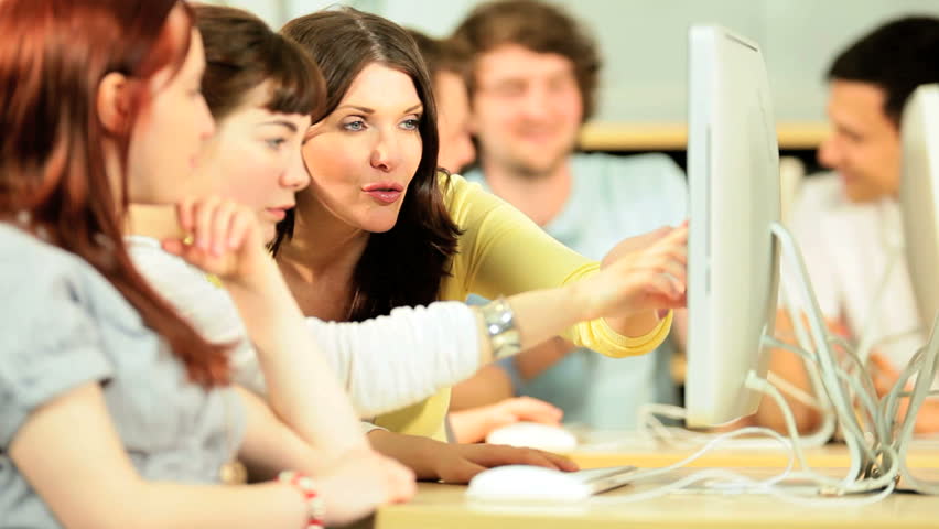 Multi ethnic happy students e-learning with female lecturer in college IT library