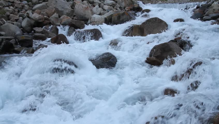 The mountain river among a heap of stones early in the morning
