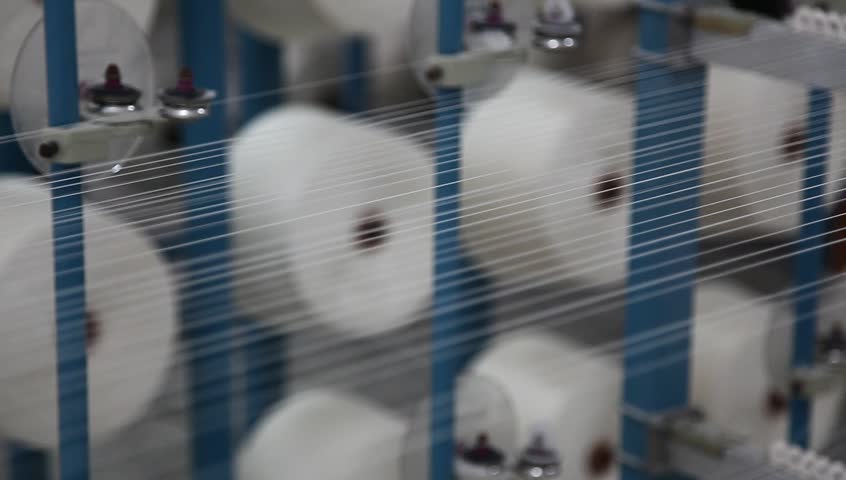 working spin machine in a cloth factory, the machine collects all the threads together