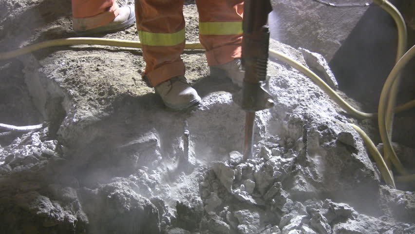 Jackhammer. Good audio. Medium shot. Road crew working at night under bright lights.