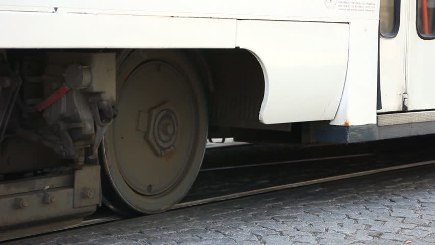 Tram wheels start to fly round and tram drive away / Tram starts and leaves away