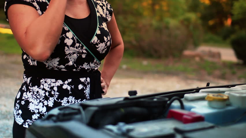 A stranded woman is frustrated by her disabled vehicle.
