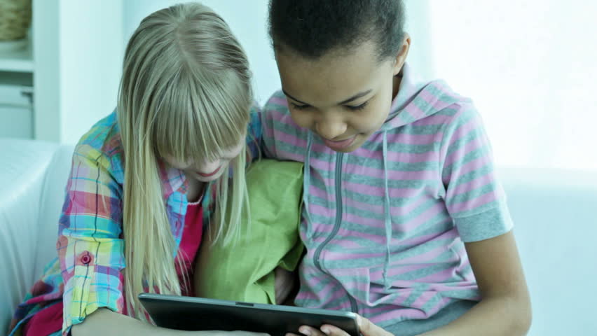 Children having a rest watching their favorite cartoons on the tablet computer screen