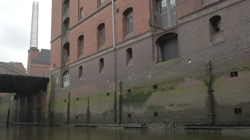 Sail along the red-brown old brick wall on the Elbe river in Hamburg. pov. 