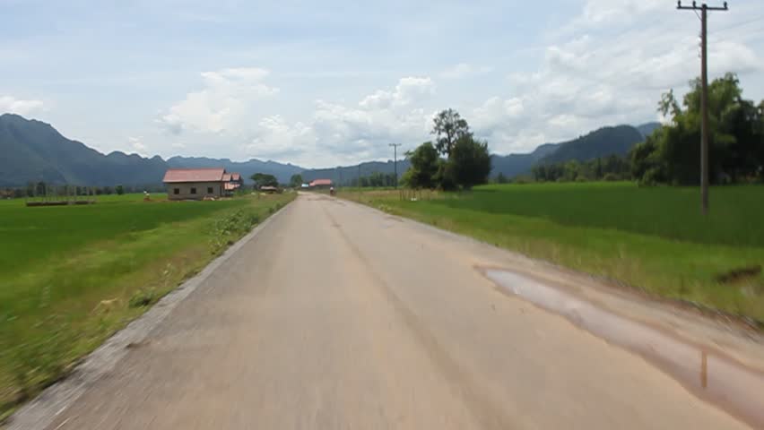 View from a local mean of transport (passenger truck) during the ride through a countryside in central Laos