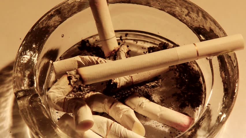 A burning cigarette in an ashtray