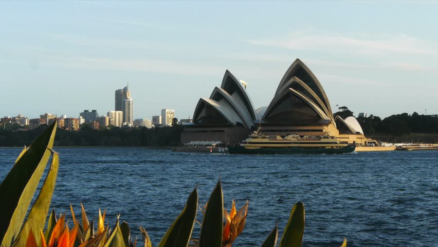 SYDNEY, AUSTRALIA - September 26: Sydney Opera House, view from Milson Pt, on September 26, 2012 with bird of paradise flowers in bloom and the Manly ferry in the foreground