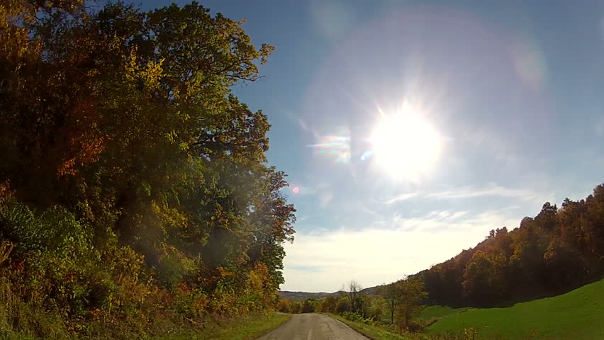 Fall Country Road in Motion â Tracking shot following a winding rural road in the height of Fall, blue sky and bright sunshine. Wisconsin countryside, Midwestern United States. 