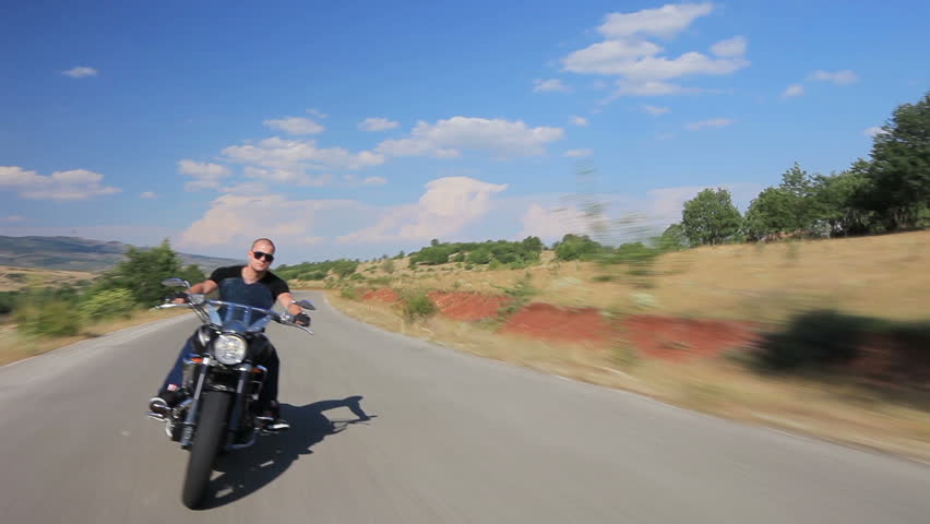 A biker riding a customized motorcycle on an open road