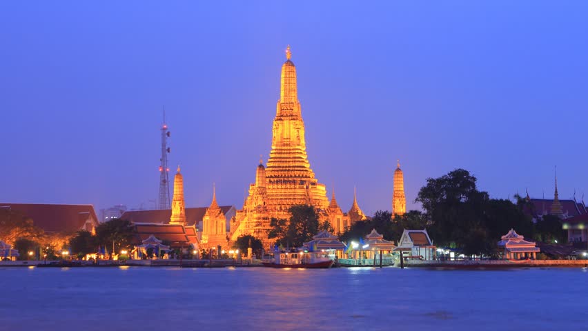 Twilight view of Wat Arun across Chao Phraya River during sunset in Bangkok, Thailand