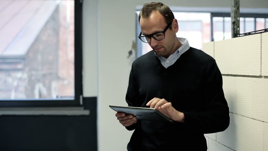 Businessman with tablet computer in the office hall
