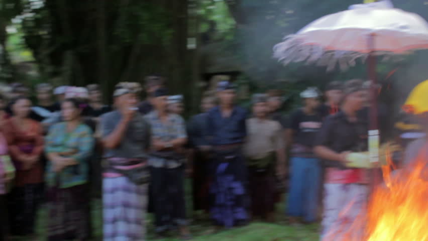 BALI - MAY 2012: burning dead body in Balinese funeral with various people