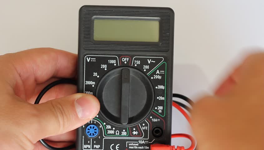 Man measures digital multimeter 